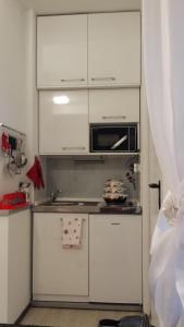 a kitchen with white cabinets and a microwave at Studio Apartment Kala in Split