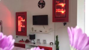 a living room with red cabinets and a tv at Studio Apartment Kala in Split