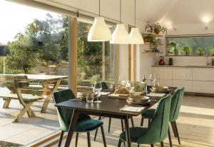 a dining room with a black table and green chairs at Slackbrae in Forest Mill