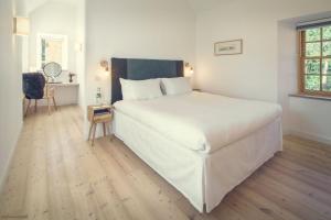 a large white bed in a bedroom with a wooden floor at Slackbrae in Forest Mill