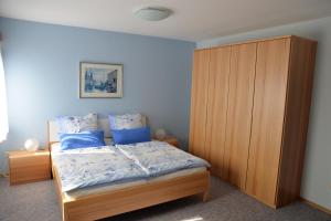 1 dormitorio con 1 cama y armario de madera en Ferienwohnung Dürnbach, en Albstadt
