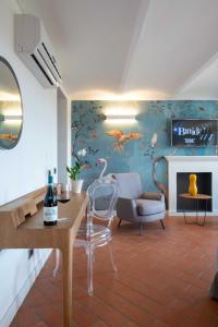 a living room with a wall with a painting of birds at Braida Wine Resort in Rocchetta Tanaro