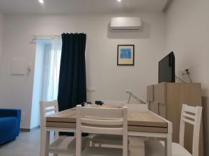 a dining room with a table and a tv at Casa Verdemare in Ischia