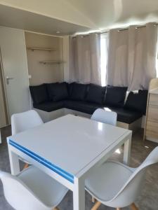 een woonkamer met een witte tafel en witte stoelen bij Mobil-home Magnolia 300m de la plage Ambleteuse in Ambleteuse