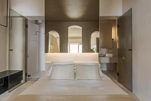 a bedroom with a bed with a large mirror at Seascape Villa by Caldera Houses in Imerovigli