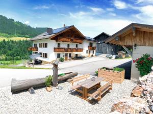 a building with a table and benches in front of it at Apartments Frechhof in Schladming