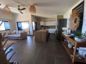 a living room with a couch and a kitchen at Le Cocon du Lagon in La Saline les Bains