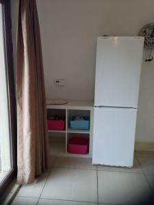 a white refrigerator in a kitchen next to a window at Killarney , Ring of Kerry 2 Bed Apartment 2 Bathrooms in Killarney