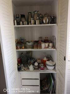 un garde-manger rempli de vaisselle, de casseroles et de poêles dans l'établissement Appartement médina Salé, à Sale