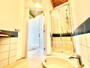 a bathroom with a tub and a shower and a sink at Le Corti Sarde Sea Breeze in Bari Sardo