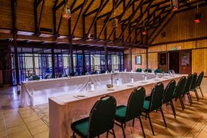 a long table in a room with green chairs at Imvubu Lodge in Richards Bay