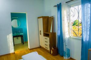 sypialnia z lustrem, komodą i oknem w obiekcie Room in Villa - The blue room is an accent of modernity in the silence of the surrounding garden w Antananarywie