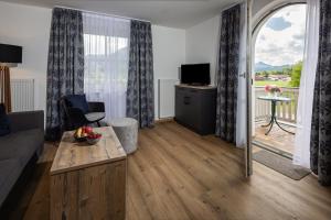 a living room with a large window and a couch at Hubertus Appartements Inzell in Inzell