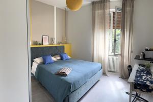 Un dormitorio con una cama azul y una ventana. en Guesthouse Margherita di Parma, en Parma