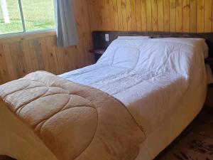 uma cama grande num quarto com uma janela em Cabana Azinheira em Urubici