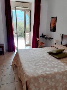 a bedroom with a bed and a sliding glass door at Casale Praia in Letojanni