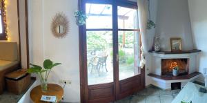 a living room with a wooden door and a fireplace at Artemisia House in Tsagarada