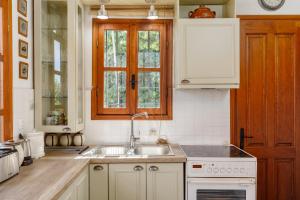 una cucina bianca con lavandino e finestra di Villa Sevasti Platamonas Holiday Home, Panel Hospitality Homes & Villas a Platamonas