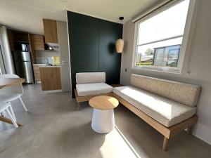 a living room with a couch and a table at O'hara mobil-home haut de gamme à 300m de la plage in Ambleteuse