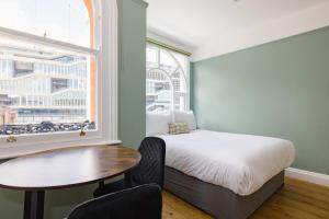 a bedroom with a bed and a table and a window at CitySpace Kings Cross in London