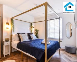 een slaapkamer met een hemelbed en een raam bij Ideal Weekly and Short Stay with Seaview in Brighton by Bluehouse Shortlets in Brighton & Hove