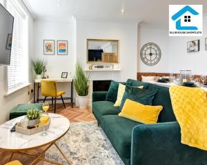 een woonkamer met een groene bank en een tafel bij Ideal Weekly and Short Stay with Seaview in Brighton by Bluehouse Shortlets in Brighton & Hove