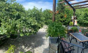 un patio con mesa, sillas y árboles en Artemisia House en Tsagarada