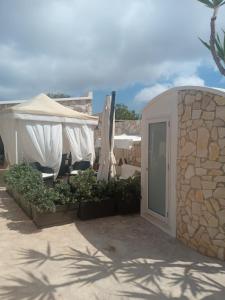 a building with a patio with chairs and umbrellas at Villa Lucia in Lampedusa
