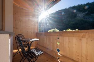 a table and chair on a balcony with a window at Hotel Gasthof Klause Dependance 2 in Reutte