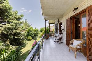 un balcone di una casa con sedie e fiori di Villa Sevasti Platamonas Holiday Home, Panel Hospitality Homes & Villas a Platamonas