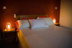 een slaapkamer met een groot bed met 2 lampen bij Room in Villa - The romantic atmosphere of the red room to discover the pleasure of a stay in Antananarivo