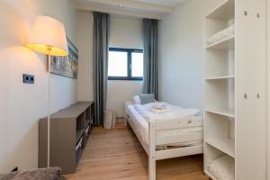 - une petite chambre avec un lit et des étagères dans l'établissement Lepelblad 42, Nieuwvliet, à Nieuwvliet