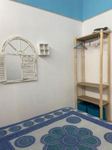 um quarto com uma cama com um tapete azul e uma prateleira em Casa vacanze stella marina em Trappeto