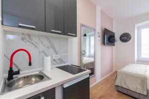 a kitchen with a sink and a bed in a room at Apartments & rooms SIX in Rijeka