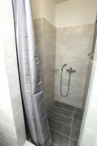 a bathroom with a shower with a shower curtain at Old Town Hall Suites and Apartments in Athens