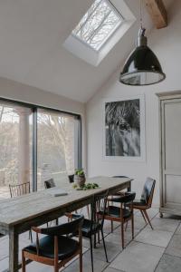 a dining room with a wooden table and chairs at The Cotswold Farm Hideaway in Alderley