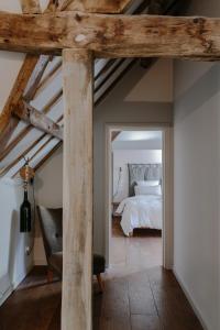 a bedroom with a bed and a chair in a room at The Cotswold Farm Hideaway in Alderley