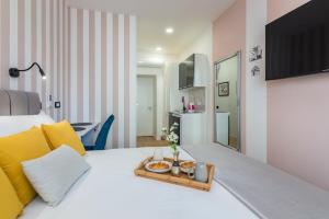 a bedroom with a white bed with a tray of food on it at Apartments & rooms SIX in Rijeka