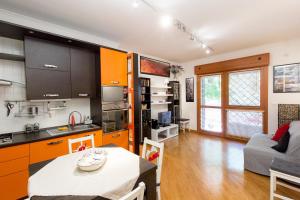 a kitchen and living room with orange cabinets at La Casetta di Giò a Roma with private garden and parking space - by Beahost in Rome