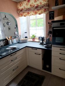 a kitchen with a black counter top and a window at Wohnung Erika in Presseck