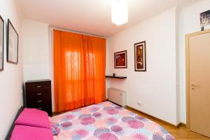 a bedroom with a bed and an orange curtain at La Casetta di Giò a Roma with private garden and parking space - by Beahost in Rome