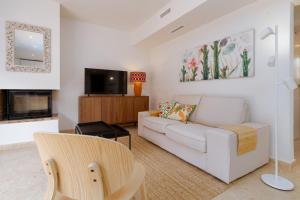 a living room with a white couch and a tv at Casa Andasol in Marbella