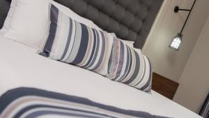 a bed with white pillows and a headboard with a lamp at Atrium Hotel Thassos in Potos