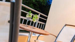 a wooden table with two glasses on a balcony at Atrium Hotel Thassos in Potos