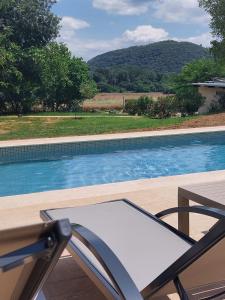 a chair next to a swimming pool with a view at El Niu Casa Rural in Montagut