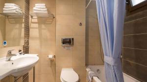 a bathroom with a sink and a toilet and a shower at Atrium Hotel Thassos in Potos