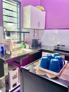 a kitchen with blue dishes in a tray on a counter at AISY HOMESTAY - Rumah 2,3 in Kampong Tanjong Karang