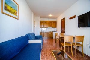 sala de estar con sofá azul y mesa en Lovely Port Europa 1 Bedroom apartment 2 Adults 1 Child, en Calpe