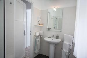 bagno bianco con lavandino e specchio di St Peter Lodge a Roma Altre 34 foto