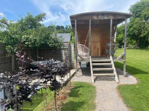 a gazebo in a garden with a staircase at La Maison du Bonheur Roulotte in Saint-Ouen-sous-Bailly